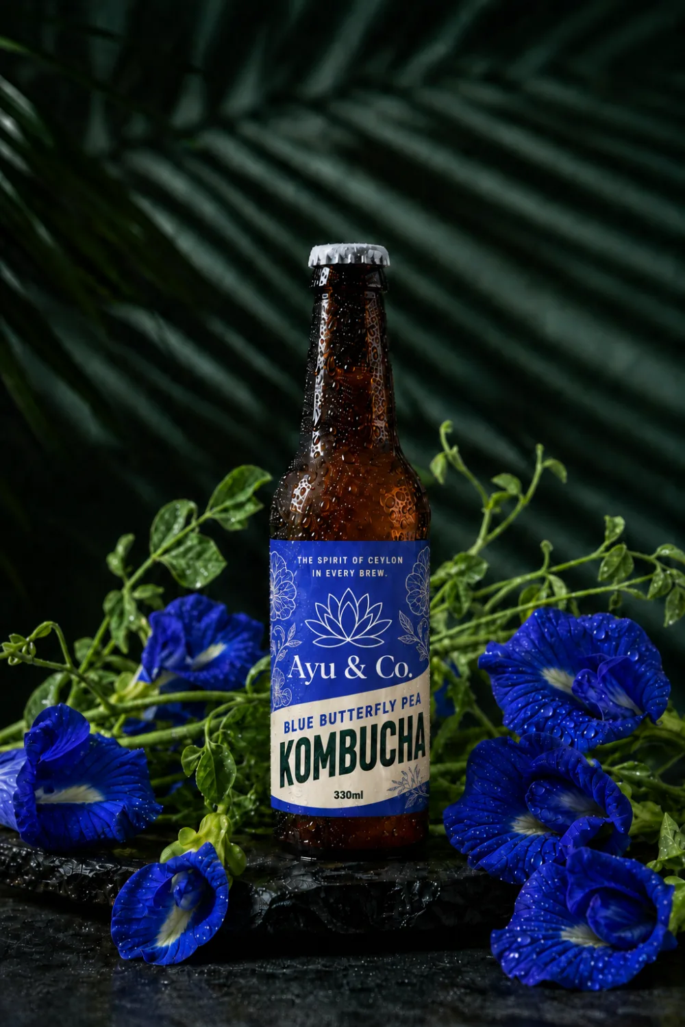 Ayu & Co. Blue Butterfly Pea Kombucha bottle nestled in vivid blue butterfly pea flowers and green vines